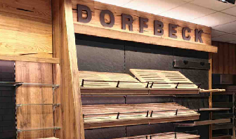 Brotregal mit „Dorfbeck“-Schriftzug.