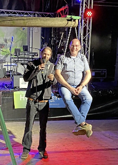 Matthias Nüsse (auf der Waage sitzend) wurde mit Wein aufgewogen, moderiert von Julian Geering. Heimatverein-Foto