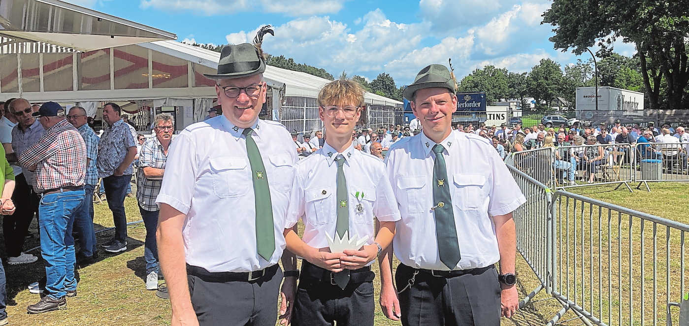 Vorsitzender Markus Meutstege, (l.) und Schießwart Marco Fischer (r.) gratulieren Jugendkönig Malte Wermes.