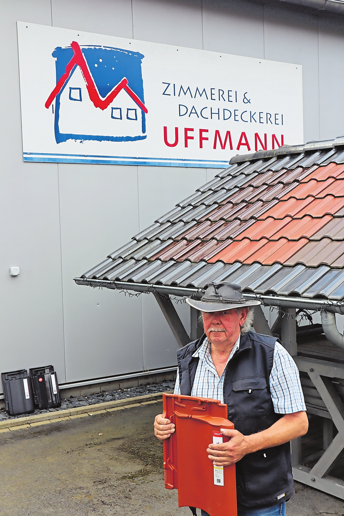 Seniorchef Martin Uffmann zeigt die Dachpfannenausstellung vor der Werkshalle.