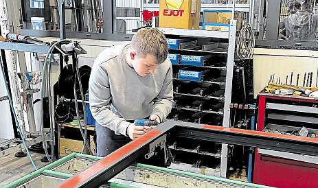 Aus zahlreichen Einzelteilen setzt Konstruktionsmechaniker-Azubi Elias ein Aluminium-Fenster zusammen. Foto: Windor (Jörg Brauer)