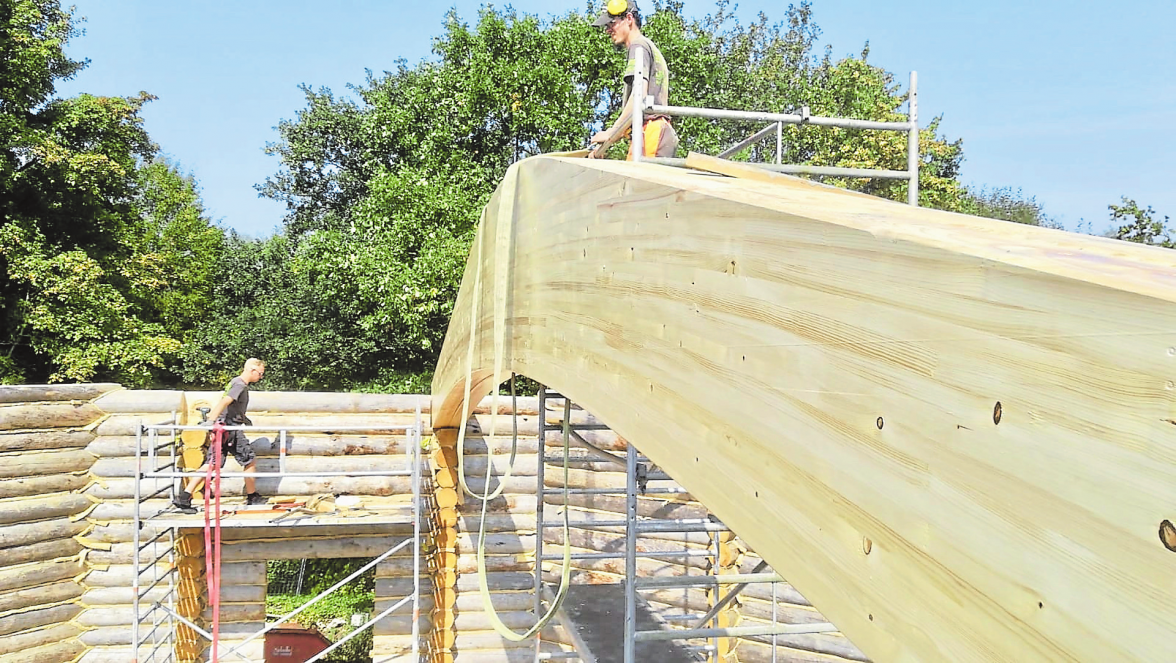 Ein tonnenschwerer Holzbalken wird für die Dachkonstruktion eingesetzt.