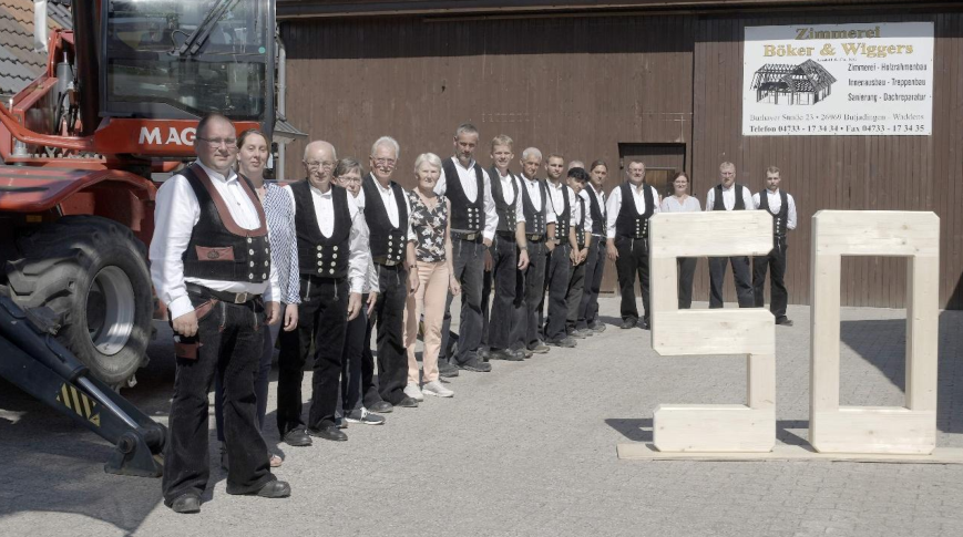 Laden am 4. September zum 50-jährigen Firmenjubiläum ein: Die Belegschaft der Zimmerei Böker & Wiggers. Vorne, von links: Tobias Müller, Anneke