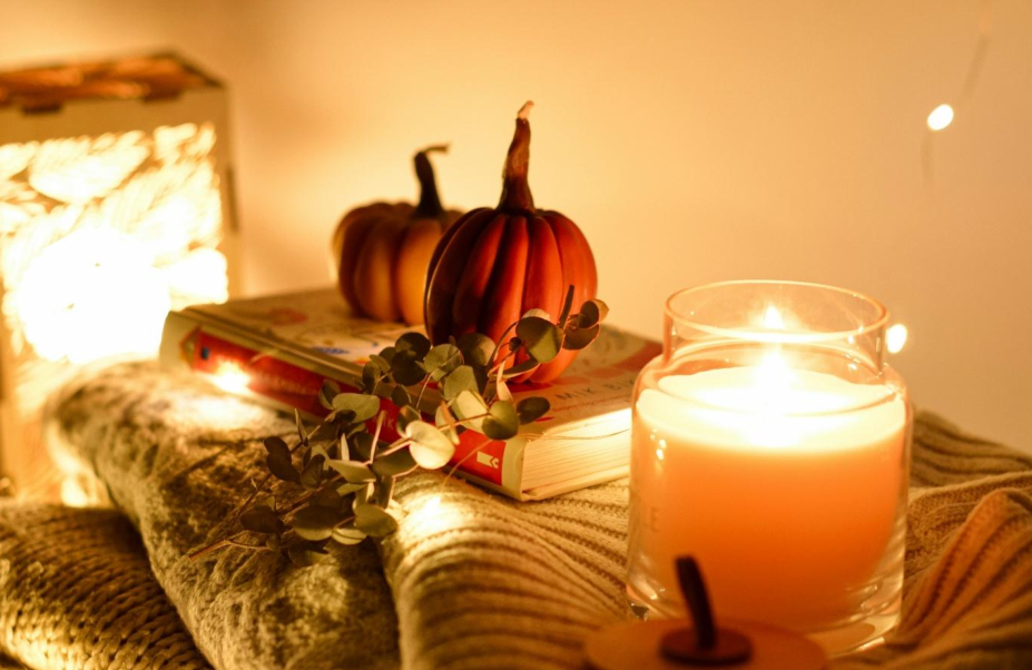 Kerzen, Kürbisse, eine Laterne und liebevoll arrangierte Details schaffen eine warme Atmosphäre, die den Zauber des Herbstes ins Zuhause holt. Bild: Anastasiia Romanska/Unsplash