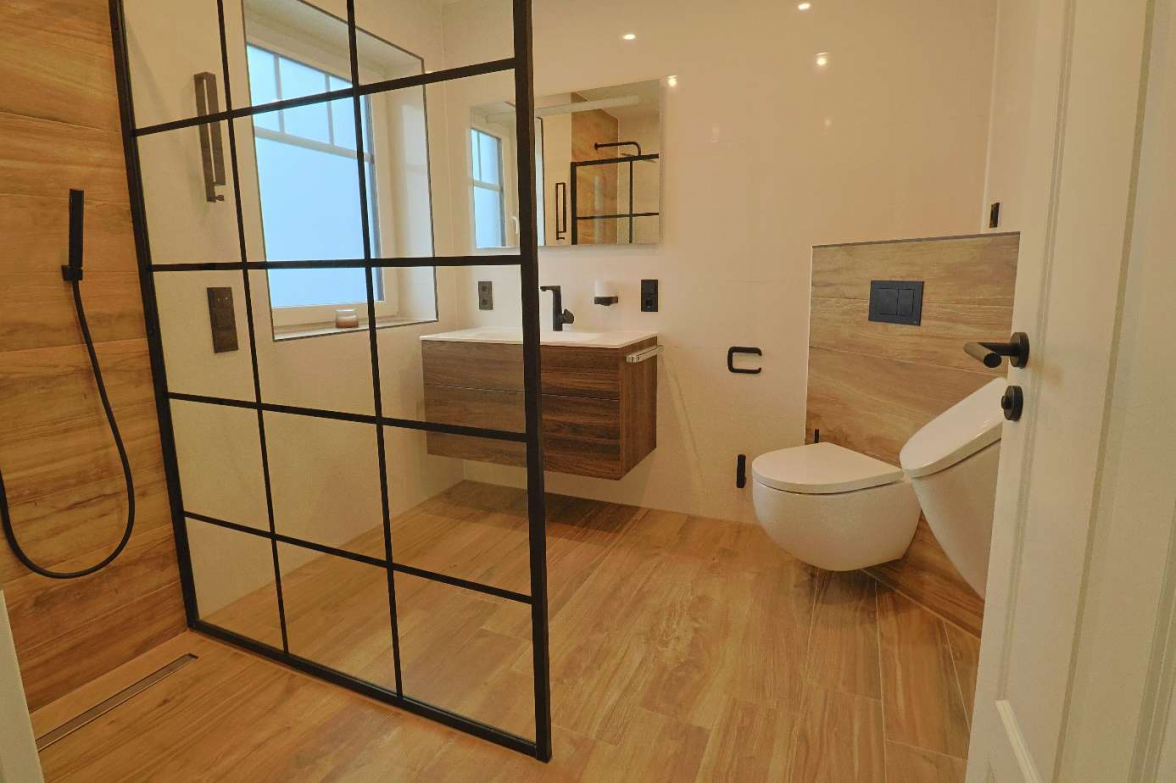 Stylisch und praktisch ist dieses Bad mit ebenerdiger Dusche und Fliesen in Holzoptik. BILD: Privat