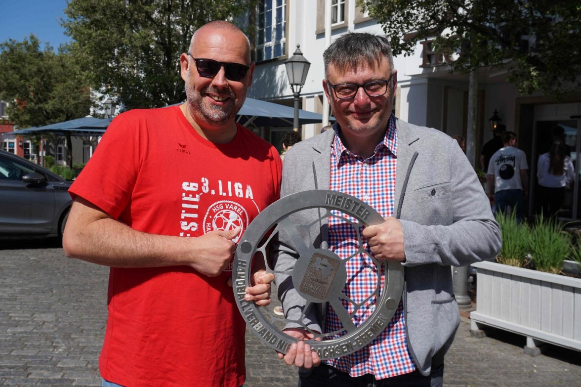 Freuen sich über die Regionalliga-Meisterschale: HSG-Trainer Arek Blacha und Christoph Deters, Sportlicher Leiter und Geschäftsführer Anker Sportmanagement. Bild: Friedhelm Müller-Düring