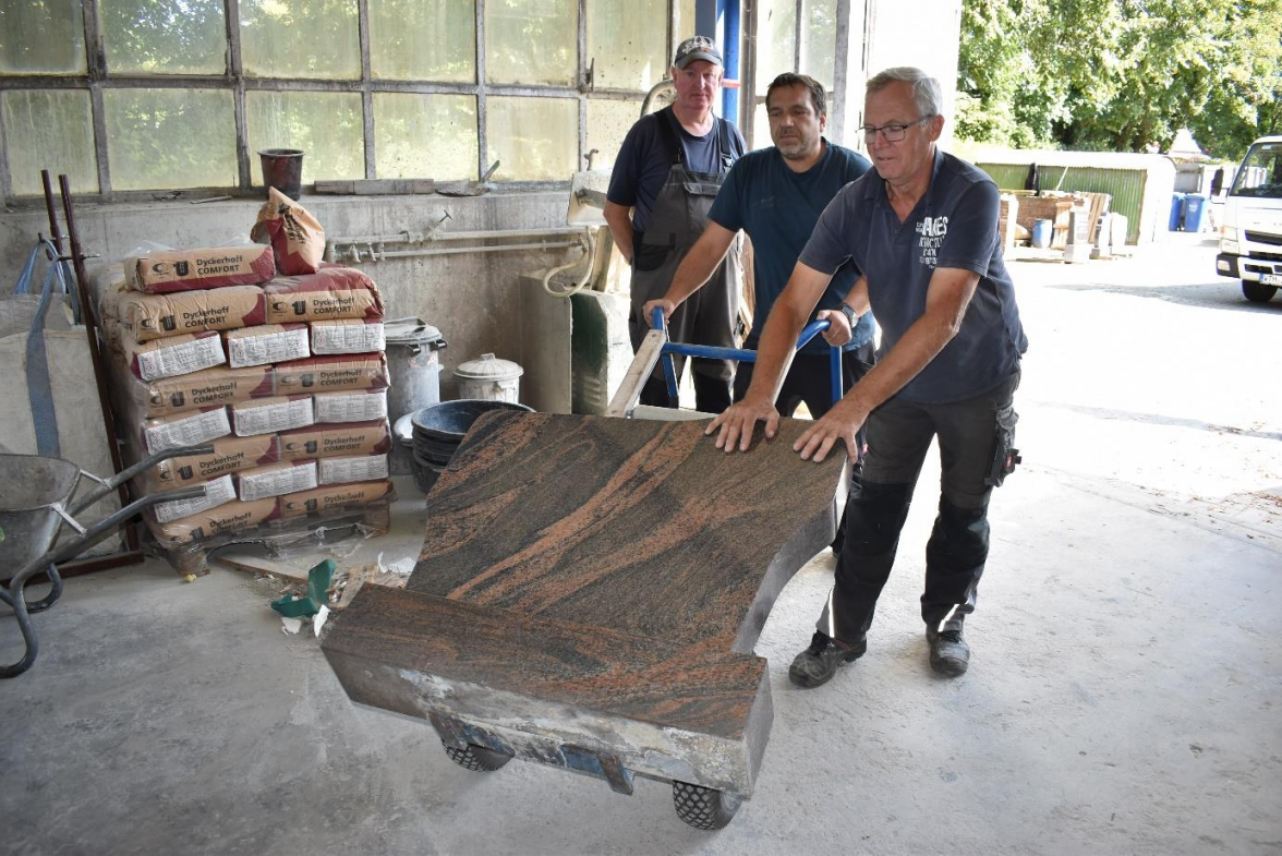 Schwerer Job: Gerhard Ihnen, Holger Hesse und Jabbo Redelfs (v.l.) mit einem unbeschrifteten Grabstein. BILD: Frank Brüling