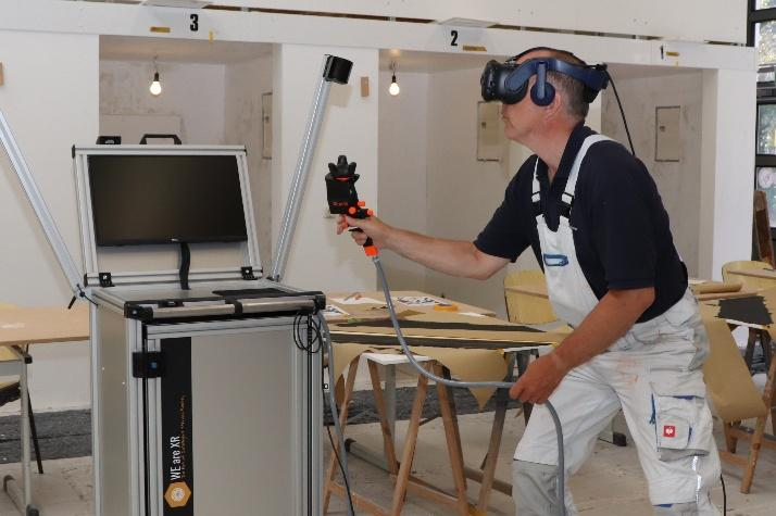 Mit einer VR-Anwendung und digitaler Lackierpistole wird in der Malerhalle das reale Lackieren in die digitale Welt transportiert. Gäste können ihr handwerkliches Geschick in einer virtuellen Lackierkabine mit realitätsnaher Umgebung testen. BILD: HWK