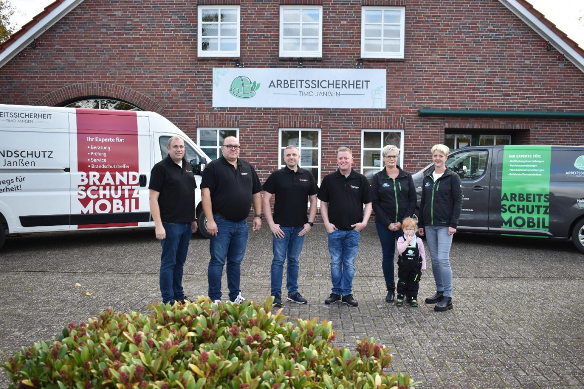Timo Janẞen (v.1.), Hartmut Schoon, Timo Rahmann, Benjamin-Chris Wiebusch, Kerstin Dunkel und Timo Janẞens Frau Silke mit Töchterchen Merle vor dem neuen Firmensitz an der Heglitzer Straße 37 in Ardorf. BILD: Frank Brüling