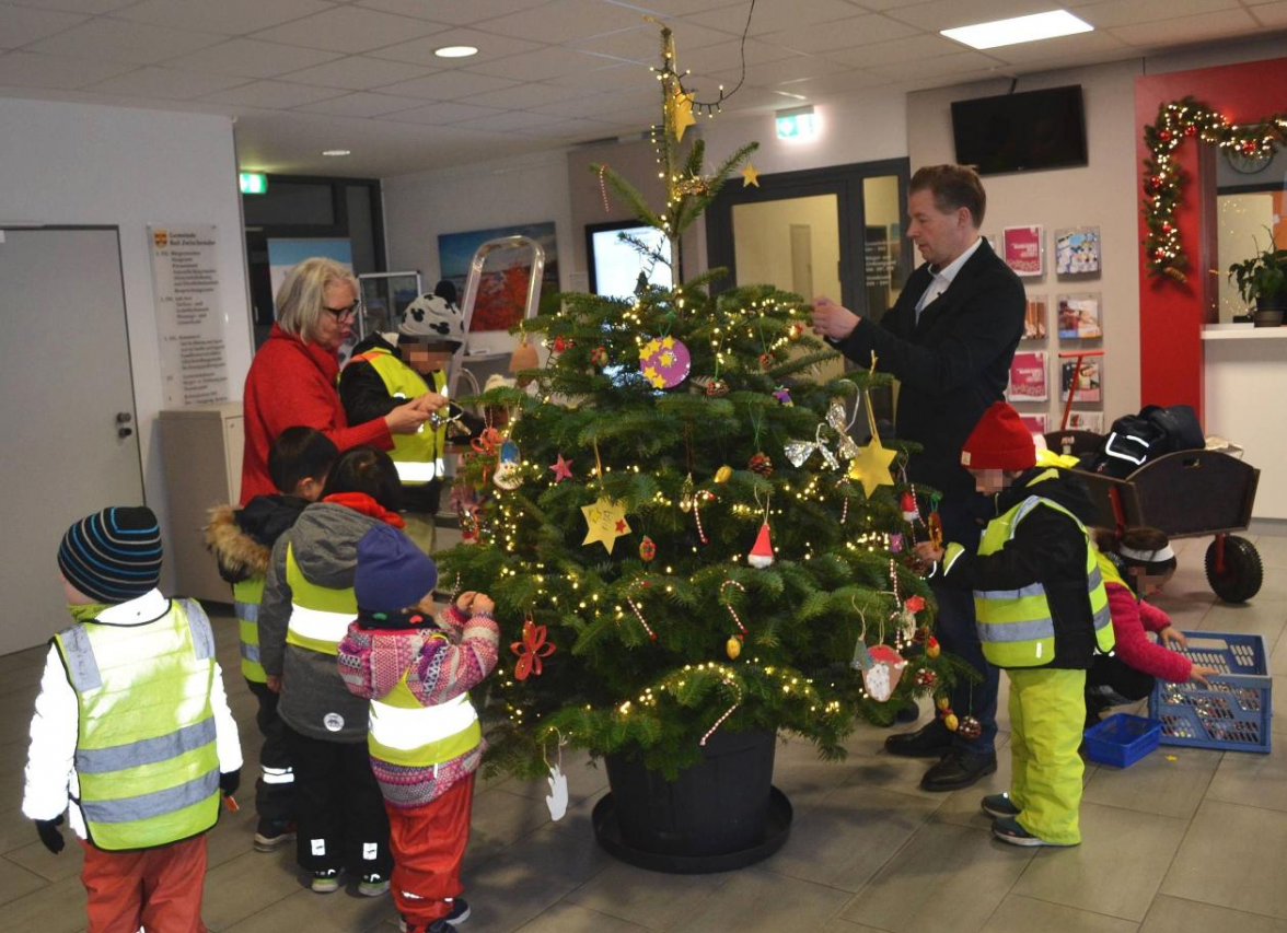 Schmückten gemeinsam den Weihnachtsbaum im Rathausfoyer: Kulturbeauftragte Sabine Krüger, Bürgermeister Henning Dierks und die Krippen- und Kindergartenkinder aus der DRK-Kita Mozartstraße. Bild: Gemeinde Bad Zwischenahn