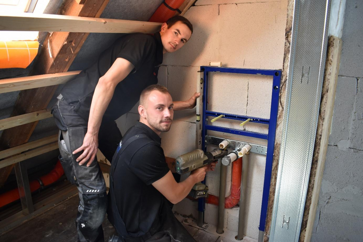 Die Gesellen Leon Erdmann und Christopher Behrends bei der Vorbereitung eines Waschbeckenanschlusses im Rahmen einer Altbausanierung in Buttforde. Bild: Frank Brüling