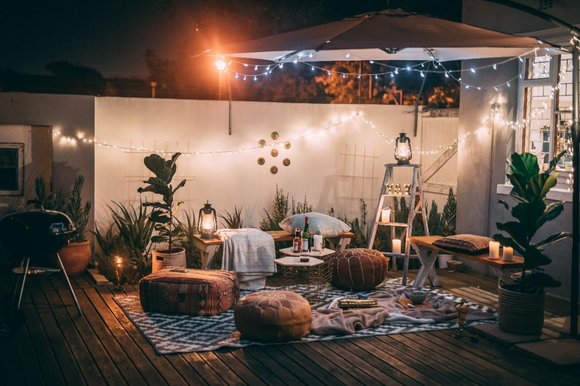 Lichterketten, ein wetterfester Teppich, weiche Sitzkissen und stimmungsvolle Laternen verwandeln die Terrasse in ein wohnliches Outdoor-Wohnzimmer mit Herbstflair. BILD: Taryn Elliott/Pexels