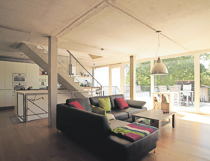 DIE BETONKONSTRUKTION BESTEHT AUS HALBFERTIGTEILEN UND BLIEB IM WOHNBEREICH SICHTBAR. KÜCHE, WOHN- UND ESSBEREICH IST EIN GROSSER BALKON VORGELAGERT.