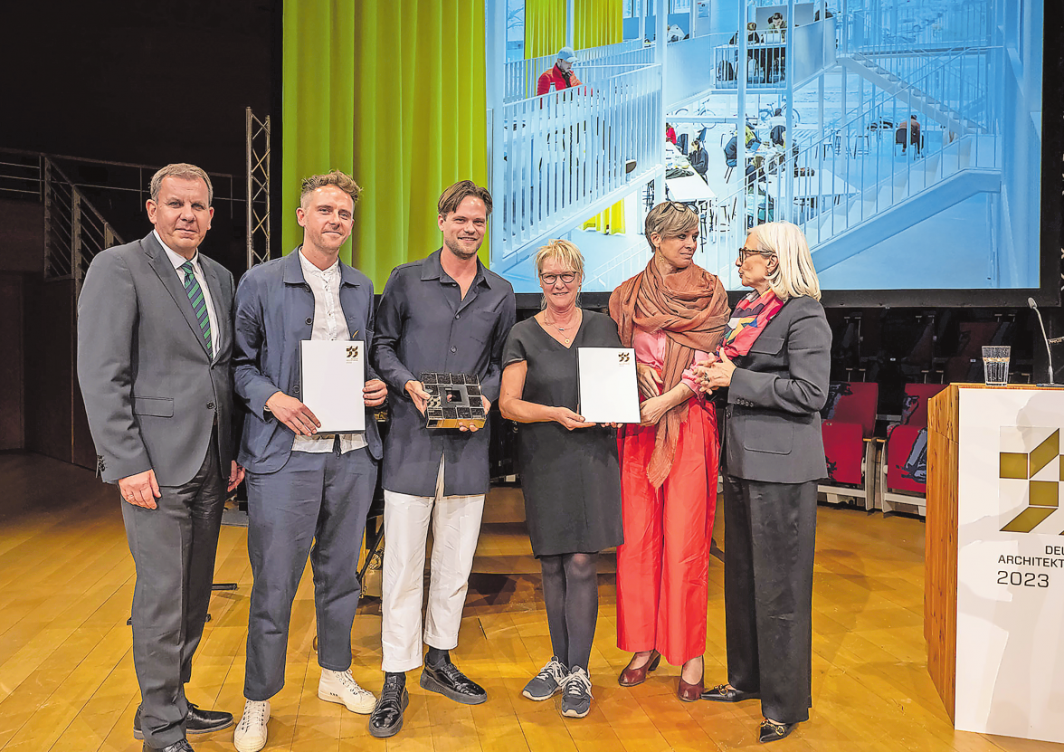 DER HAUPTPREIS DES DEUTSCHEN ARCHITEKTURPREISES 2023 GING AN DIE BEIDEN JUNGEN BERLINER ARCHITEKTEN MAX HACKE UND GUSTAV DÜSING. IM BILD: DIRK SCHEINEMANN, ABTEILUNGSLEITER IM BUNDESBAUMINISTERIUM, DIE ARCHITEKTEN MAX HACKE UND GUSTAV DÜSING, BETTINA NÖHREN UND TATJANA SCHNEIDER VON DER TU BRAUNSCHWEIG UND ANDREA GEBHARD, PRÄSIDENTIN DER BUNDESARCHITEKTENKAMMER (V. L. N. R.) FOTO: CHRISTOPH PETRAS