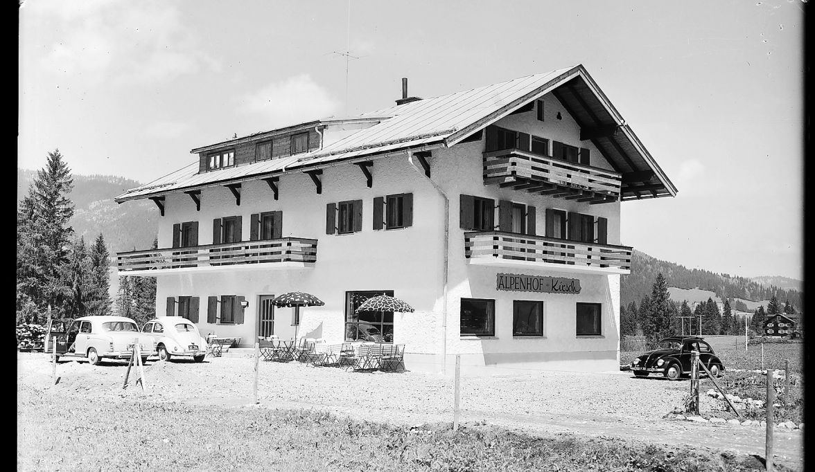 POSTKARTENMOTIV MIT VW-KÄFERN: ZU DEN NEUEREN BAUTEN ZÄHLT DER „ALPENHOF KIRSCH“ IN RIEZLERN IM KLEINWALSERTAL, WOHL IN DEN SPÄTEN 1950ER JAHREN FOTOGRAFIERT.