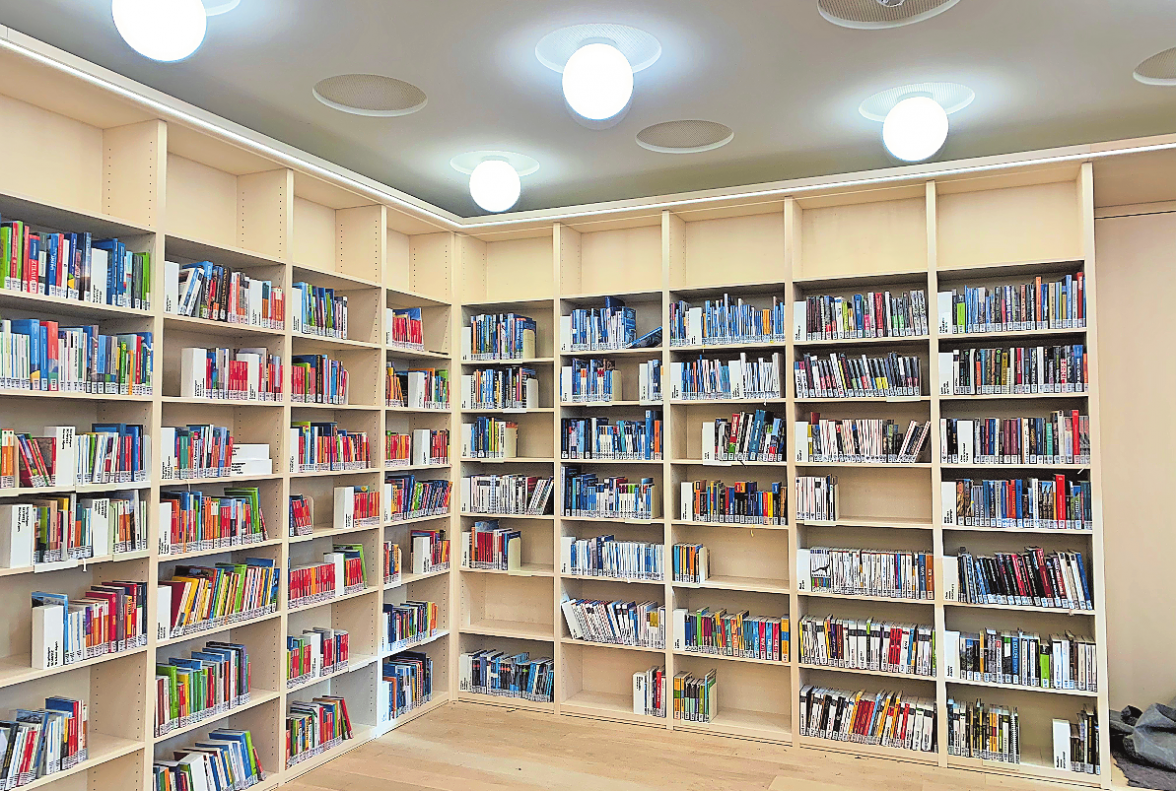 LUFTIG, LICHT UND HELL: DIE REGALE DER NAGELNEUEN DECKENHOHEN BIBLIOTHEK IM ERDGESCHOSS BERGEN SACHBÜCHER UND SCHÄTZE DER ALPINLITERATUR – INSGESAMT DIE GRÖSSTE SAMMLUNG WELTWEIT.