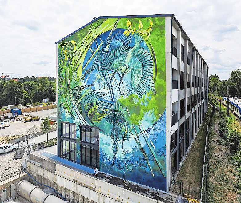 DIE RUND 300 QUADRATMETER GROSSE FASSADE AM STERNRAD-HAUS DURFTE NACH WETTBEWERB DAS KÜNSTLERKOLLEKTIV VIDEO.SCKRE GESTALTEN.