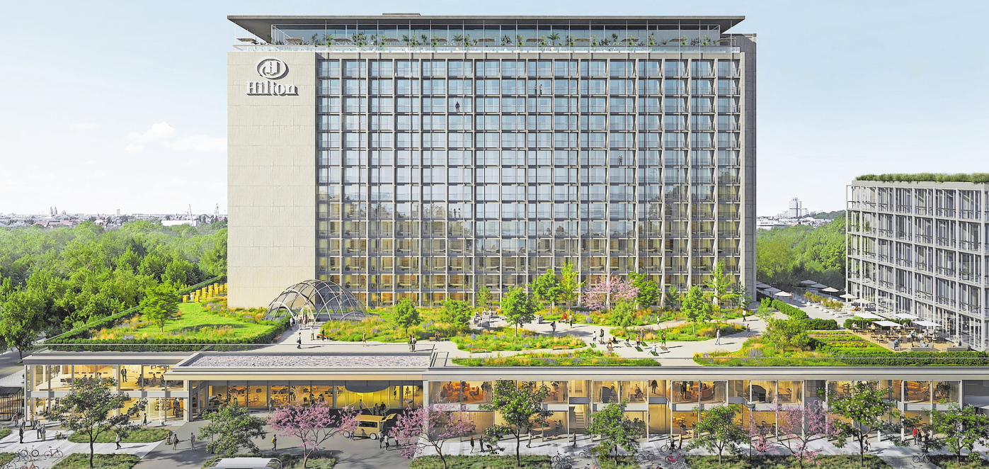 DAS 52 METER HOHE HOTEL HILTON HAT DEN BETRIEB BEREITS EINGESTELLT, UM UMFASSEND SANIERT NACH VIER JAHREN IM RAHMEN DER TUCHERPARK-FERTIGSTELLUNG WIEDER ZU ERÖFFNEN.