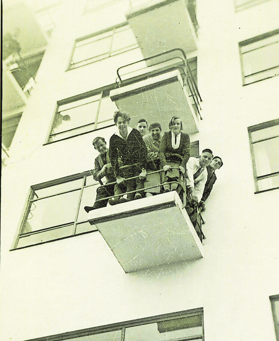 Ein historischer Moment: Bauhäuslerinnen und Bauhäusler auf einem Balkon des Bauhaus-Gebäudes. Foto: Stiftung Bauhaus Dessau