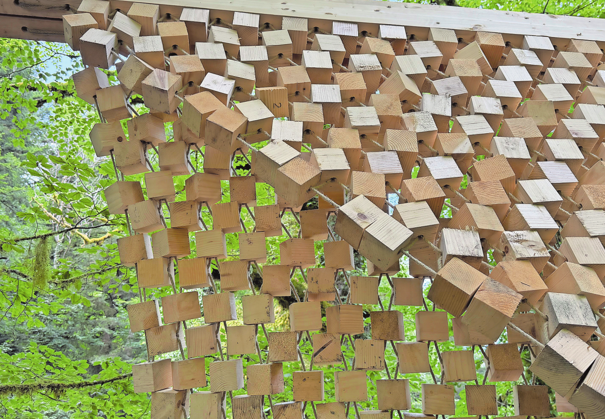 EIN DACH WIE EIN NETZ. SEILE UND HOLZKLÖTZCHEN SIND ZWISCHEN ZWEI BÄUME GESPANNT.   FOTOS: PATRIZIA STEIPE
