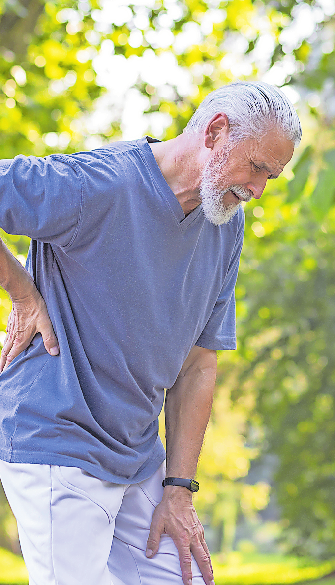 Beinschmerzen bei einer Spinalkanalstenose strahlen vom Rücken ins Bein aus und bessern sich typischerweise beim Entlasten oder Vorbeugen. Foto: Adobe Stock