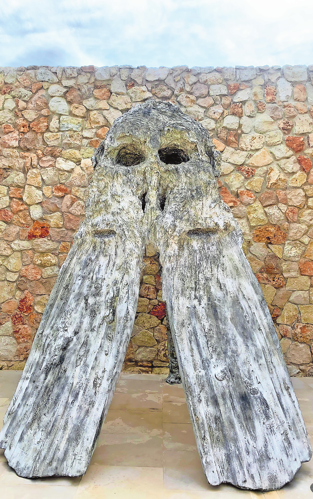 EIN BARCELÒ BEGRÜSST DIE BESUCHER AM EINGANG - DIE SKULPTUR IST VON EINER LOKALEN LEGENDE INSPIRIERT.