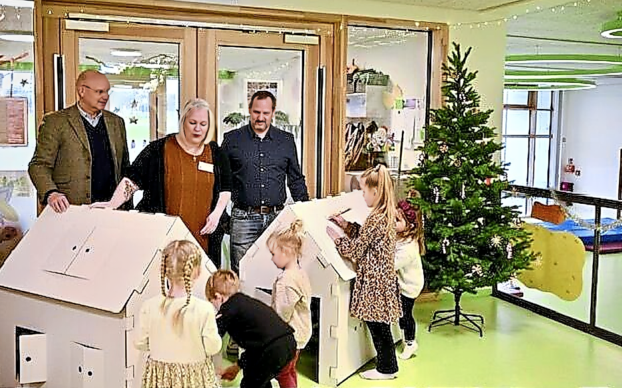 Kindergartenkinder freuen sich gemeinsam mit der Leiterin des Ev. Kindergartens Viöl, Barbara Clasen, und den Geschäftsführern Michael Klinger und Stephan Rathje über die Spielhäuser. Fotos: Andreas Weinrich
