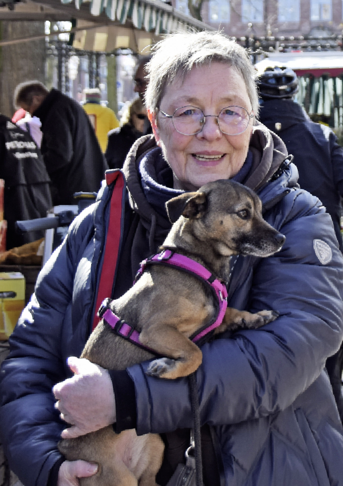 Gemeinsam mit Hund Fritzi geht Michaela Brett auf den Wochenmarkt und kauft dort unter anderem beim Obststand ein. Die Bewegung und frische Luft tun ihr gut und sie genießt das gute Wetter.