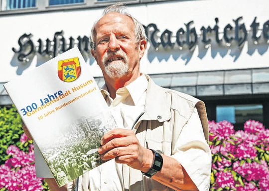 Jürgen Dietrich im Jahre 2006 vor dem Redaktionsgebäude der Husumer Nachrichten mit der Broschüre „300 Jahre Garnisonsstadt Husum / 50 Jahre Bundeswehrstandort“, die er maßgeblich mitgestaltet hat. Foto: Stefan Petersen