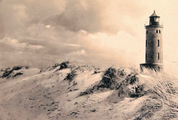 Der Böhler Leuchtturm mitten in einer Dünenlandschaft.