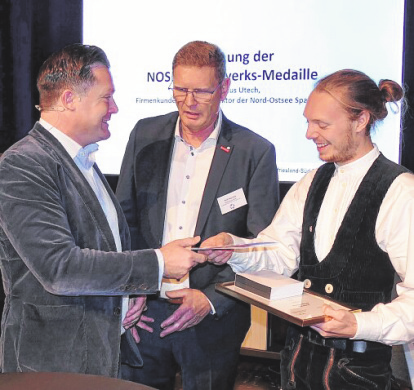 Im Beisein von Rolf Hansen (m.) überreicht Marcus Utech (I.) die NOSPA Handwerksmedaille an den Zimmerer Bennet Meyer (r.).