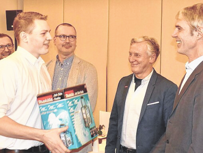Anlagenmechaniker Maurice Falk (1.) nimmt Glückwünsche vom Prüfungsausschuss und ein Präsent als Innungsbester entgegen.