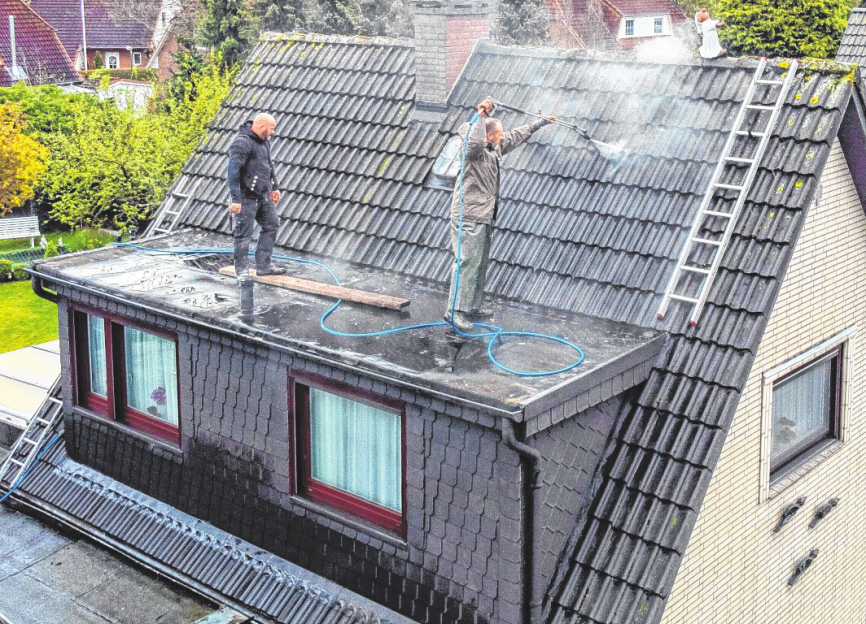 Maik Hinsch (l.) und Ralf Groß bei der Dachreinigung.