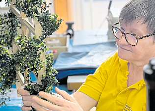 Buchsbaum aus Plastik wickelt Sabine um das Holzgestell