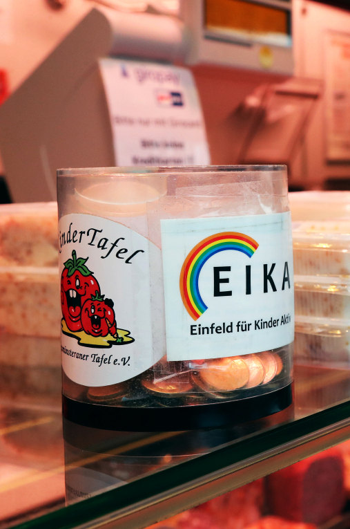 Seit vielen Jahren stehen die kleinen Spendendosen mit dem Logos der Kindertafel und Eika auf dem Verkaufstresen