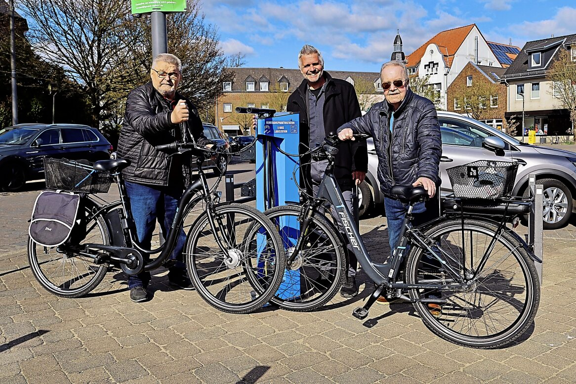 Leo Aveaux und Klaus Ladwig erkunden gemeinsam mit Bürgermeister Torben Ackermann die neue E-Bike-Ladestation.
