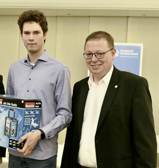 Prüfungsbester Jon Broder Martensen (I.) erhielt von Ralf Bruhn ein Präsent überreicht.