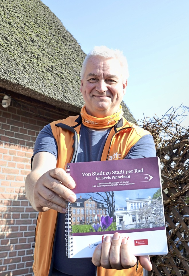 Radfahren entdecken: Ulf Brüggmann hält das ADFC-Buch „Von Stadt zu Stadt per Rad – im Kreis Pinneberg“ in die Kamera. Foto: Natascha Thölen