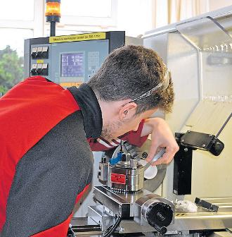 Vom Rohling zum Präzisionsteil: Justin Melzer, angehender Feinwerkmechaniker im dritten Lehrjahr, arbeitet konzentriert an der Drehmaschine und bringt Material in eine neue Form.
