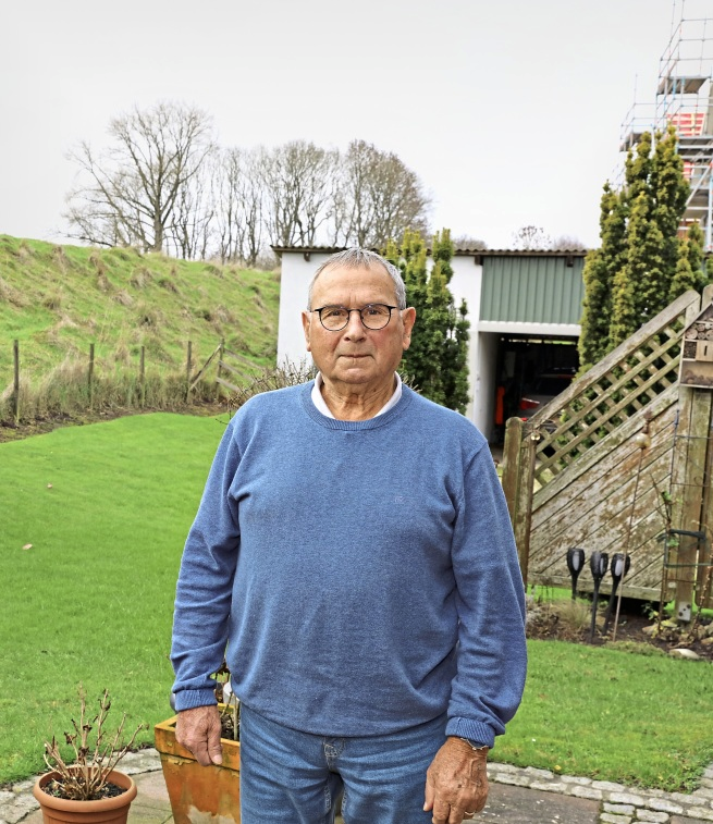 Peter Schmahl im Garten seines Elternhauses, das direkt am heutigen Innendeich steht. 1976 blieb es quasi komplett. von der Flut verschont. Foto: Bastian Fröhlig
