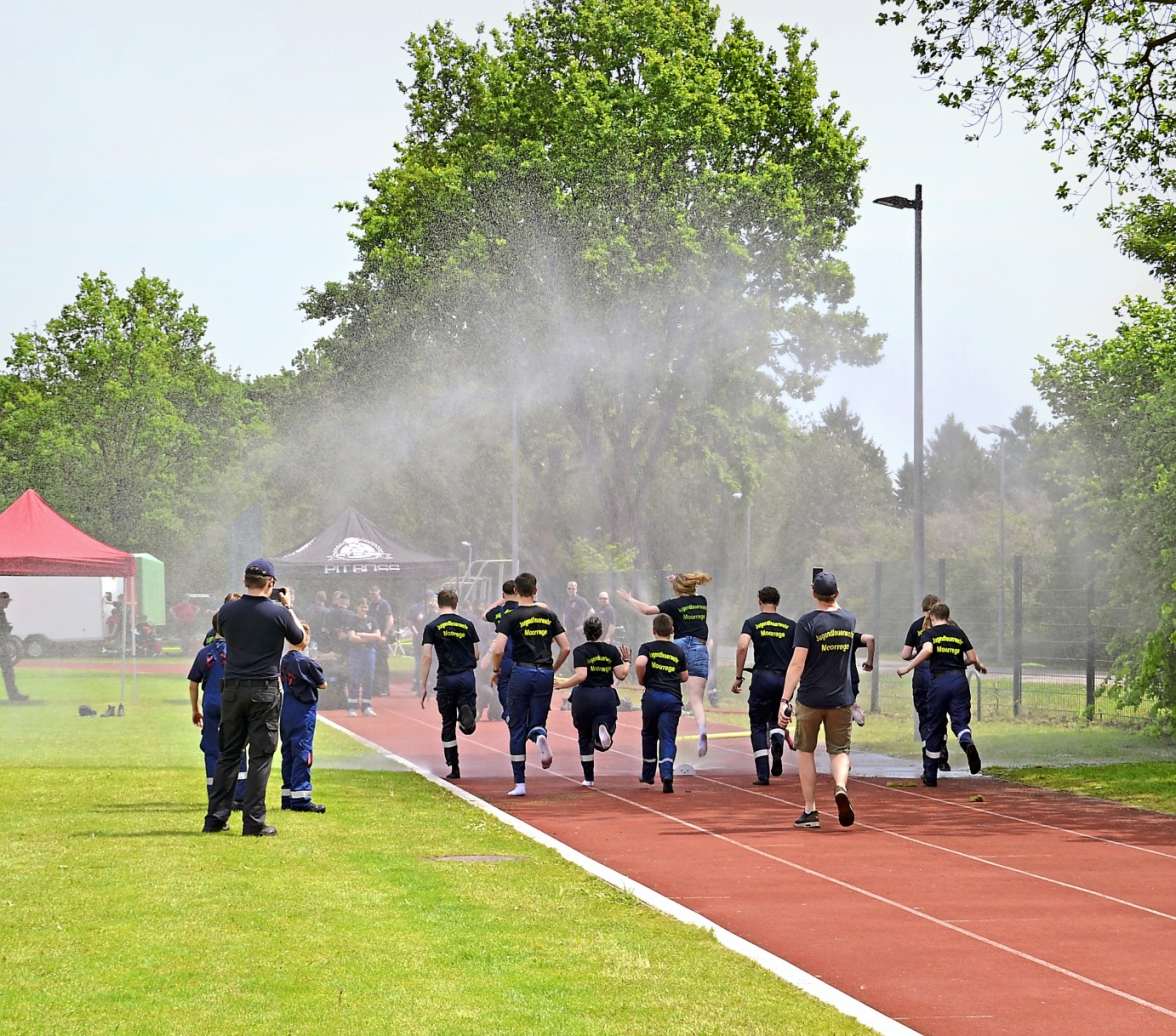 Gemeinsam macht es am meisten Spaß: Eine Gruppe der Jugendfeuerwehr Moorrege läuft durch die Wasserwand, die bei den hochsommerlichen Temperaturen für Abkühlung und jede Menge gute Laune sorgte. Fotos: Natascha Thölen