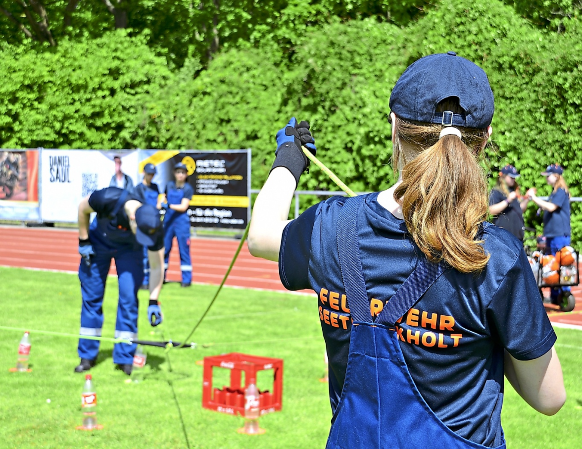 Teamarbeit und Geschicklichkeit waren beim Pfingstzeltlager gefragt: An einer der Wettbewerbsstationen versucht die Jugendfeuerwehr Seeth-Ekholt, mithilfe von Seilen Flaschen vom Boden aufzunehmen - eine Aufgabe, die nur gemeinsam zu lösen ist.