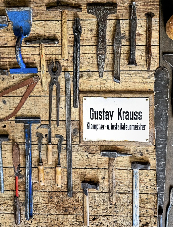 Utensilien aus früherer Zeit: Das Firmenschild umrahmt von altem Werkzeug.