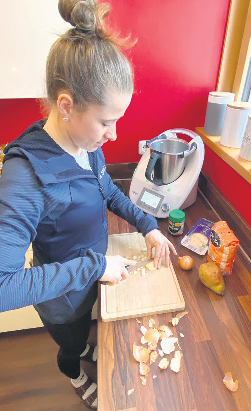 Langlauf-Olympiasiegerin Katharina Hennig aus dem Erzgebirge schnippelt in ihrer Küche die Zutaten für ihr Lieblingsgericht: Risotto mit Gorgonzola, Birnen und Walnüssen. Foto: privat