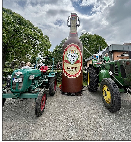 Mit Hilfe von Traktoren wird die Flasche als Symbol für den Landbiertag aufgebaut.