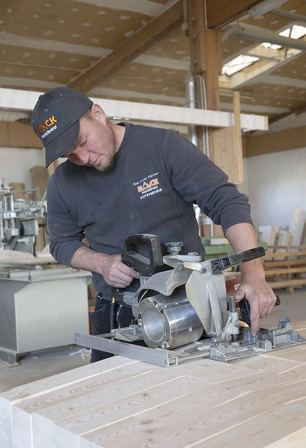 Ein Back-Zimmerer beim Abrichten von Holzbauteilen