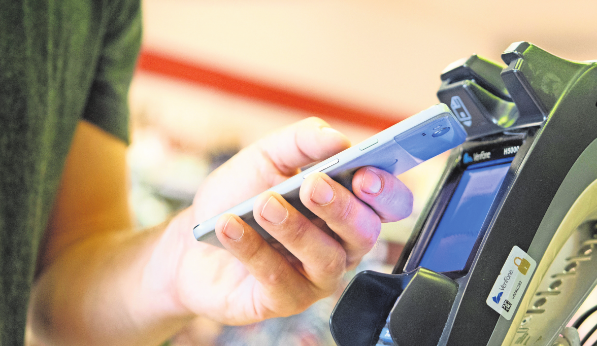 Foto: dpa Im Vorbeigehen: Wer mit dem Smartphone Einkäufe zahlt, muss nicht nach Münzen oder Karten kramen.