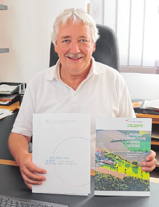 Bürgermeister Reinhard Streng mit Broschüren, die Langenfeld beispielhaft als Mehrgenerationengemeinde würdigen. Foto: Rainer Fritsch