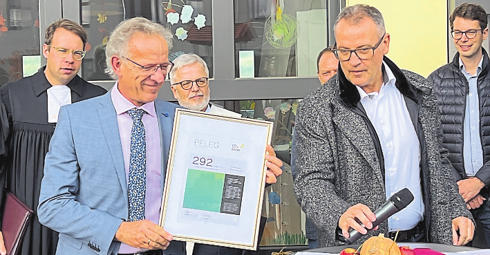 292 Tonnen CO₂ beim Kita-Bau eingespart: Die von Volker Baumgarten (rechts) überreichte Urkunde bekommt einen würdigen Platz.