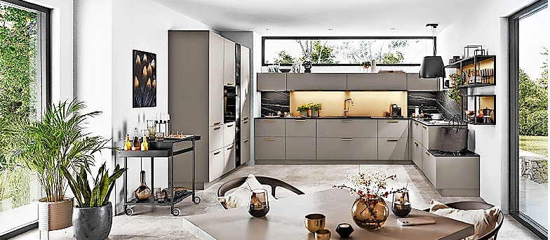 Die Trendfarbe Grau hier in einem warmen Taupe-Farbton zusammen mit dunklen Accessoires - zum Beispiel einem praktischen schwarzen Servierwagen - und feinen Goldakzenten bei den beleuchteten schwarzen Wandregalen, den dunklen Arbeitsplatten und der schwarz-goldenen Küchennische. FOTO: AMK